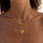 Gold necklace with a heart-shaped pendant on a person's neck