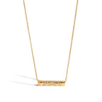 Gold necklace with a bar pendant on a white background
