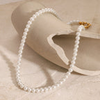 Pearl necklace with a gold clasp on a beige fabric background