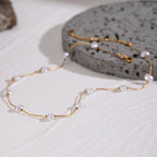 Gold necklace with pearls on a textured surface