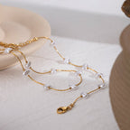 Gold necklace with pearls on a light background