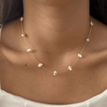 Pearl necklace on a person wearing a white top