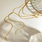 Gold chain on a beige surface with a clear glass bowl