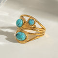 Gold ring with turquoise stones on a white background