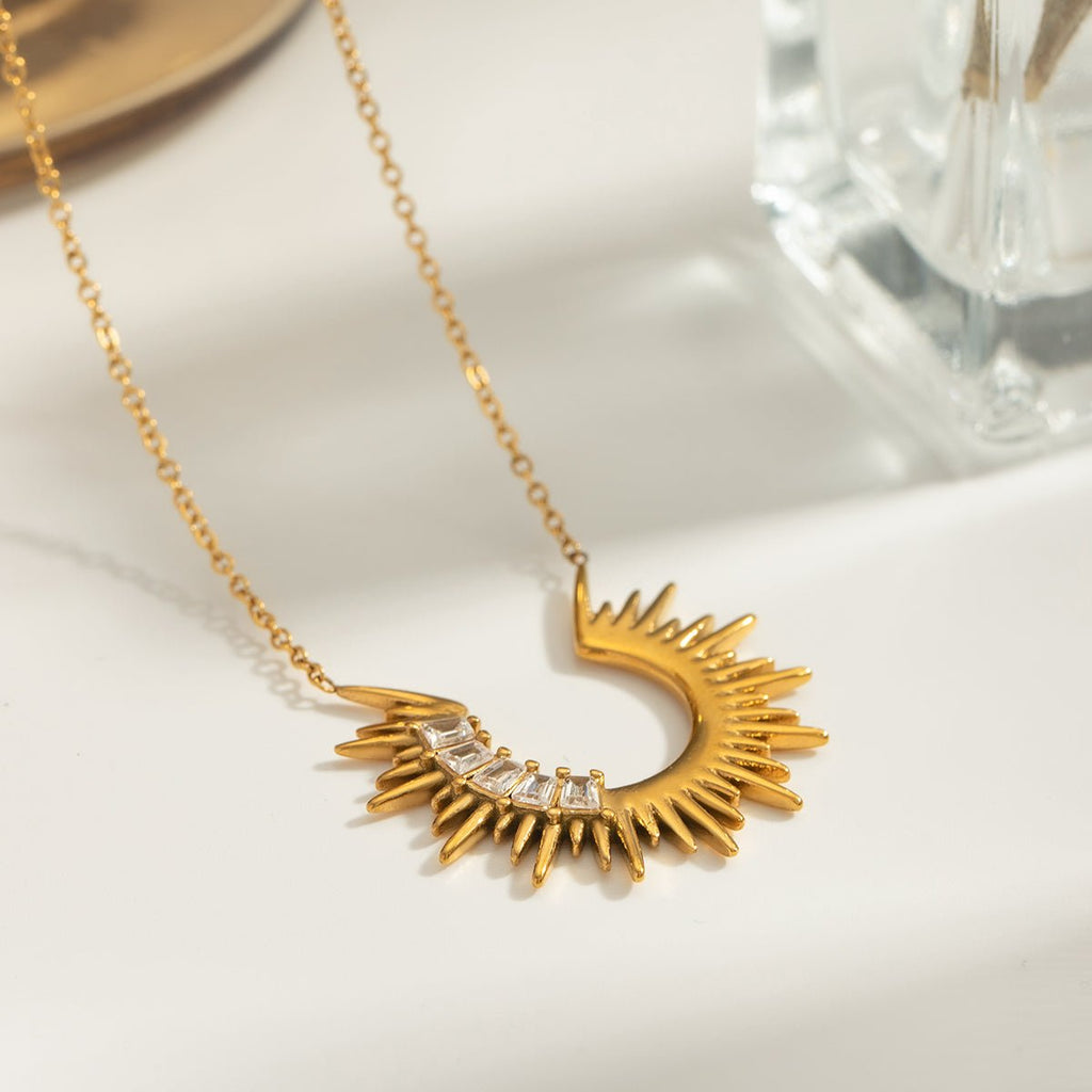 Gold necklace with a unique design on a white surface