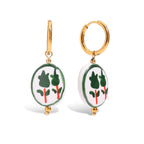Pair of earrings with green and red designs on a white background