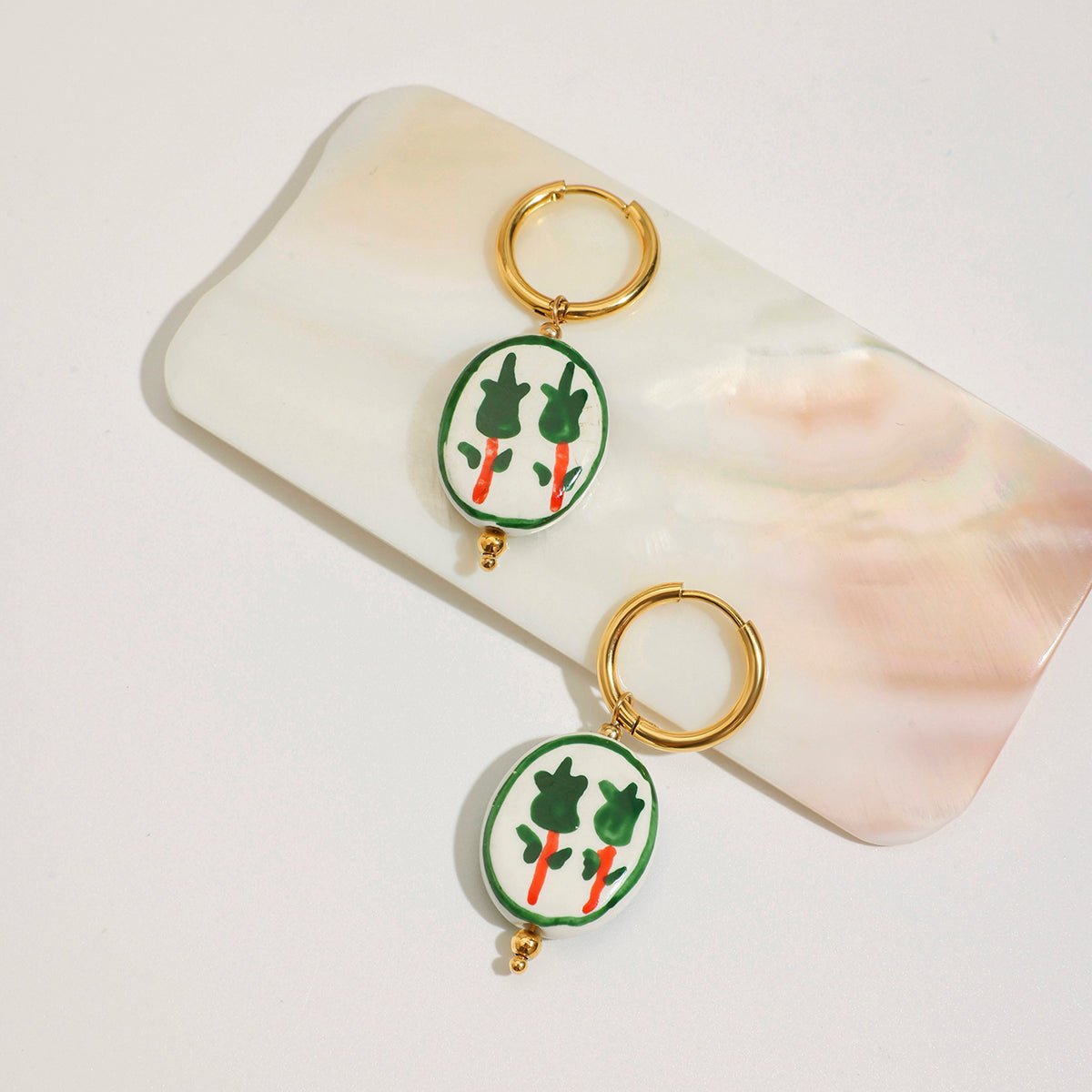 Two keychains with green designs on a white surface