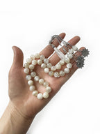 Close-up of white moonstone prayer beads, showcasing each bead’s calming luminosity