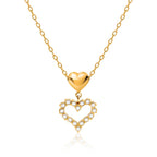 Gold heart-shaped necklace with a smaller heart pendant on a white background