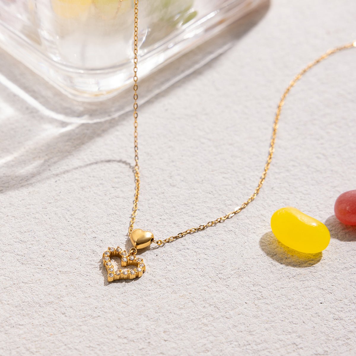 Gold necklace with heart-shaped pendant on a light background