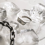 Silver ring with engraved design on ice cubes
