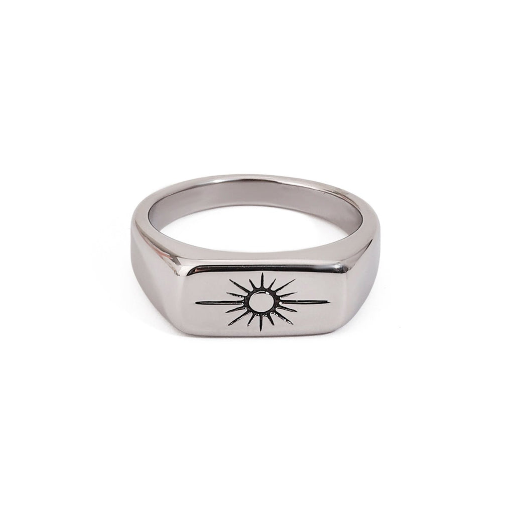Silver ring with a sun design on a white background