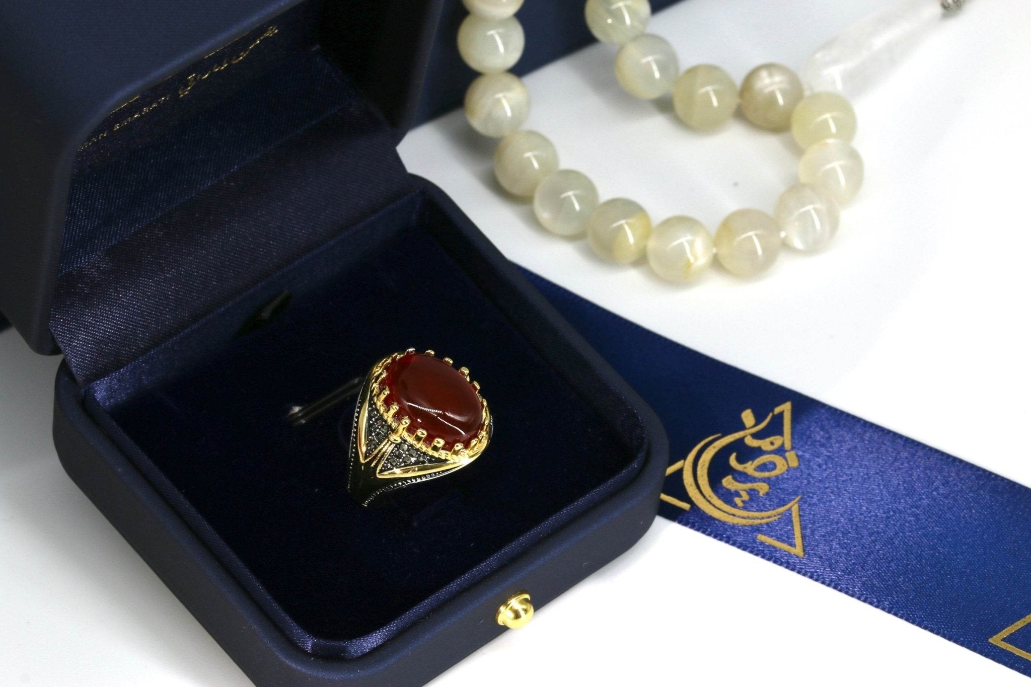 Side angle of handcrafted silver ring showing brown agate gemstone and detailed engraving
