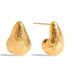 Gold earrings with a textured design on a white background