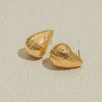 Pair of gold earrings on a light beige background