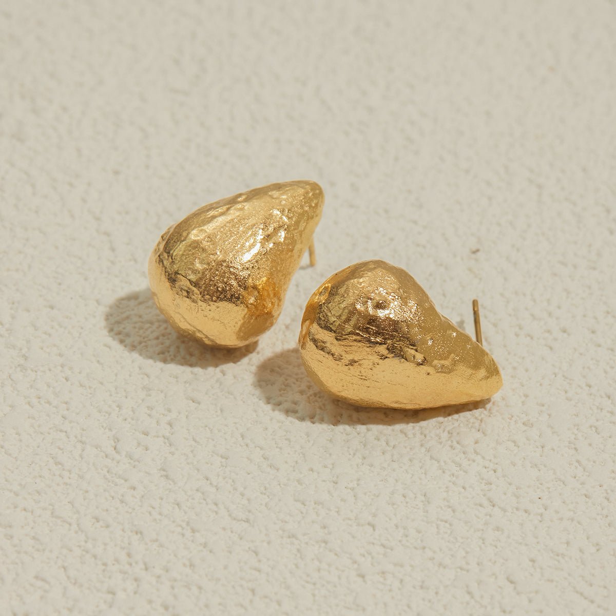 Pair of gold earrings on a light beige background