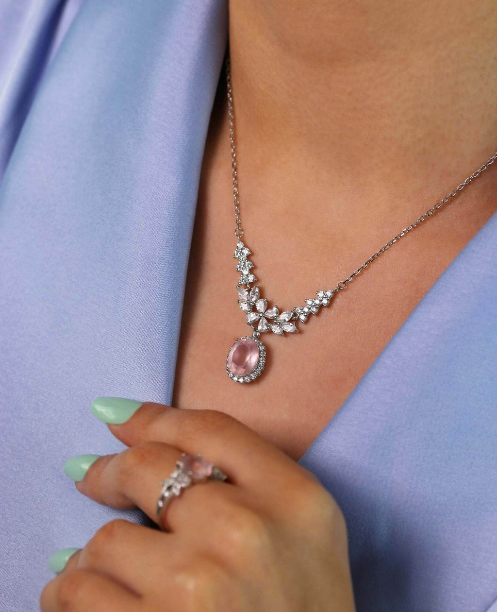 Close-up of platinum necklace with oval rose quartz centerpiece