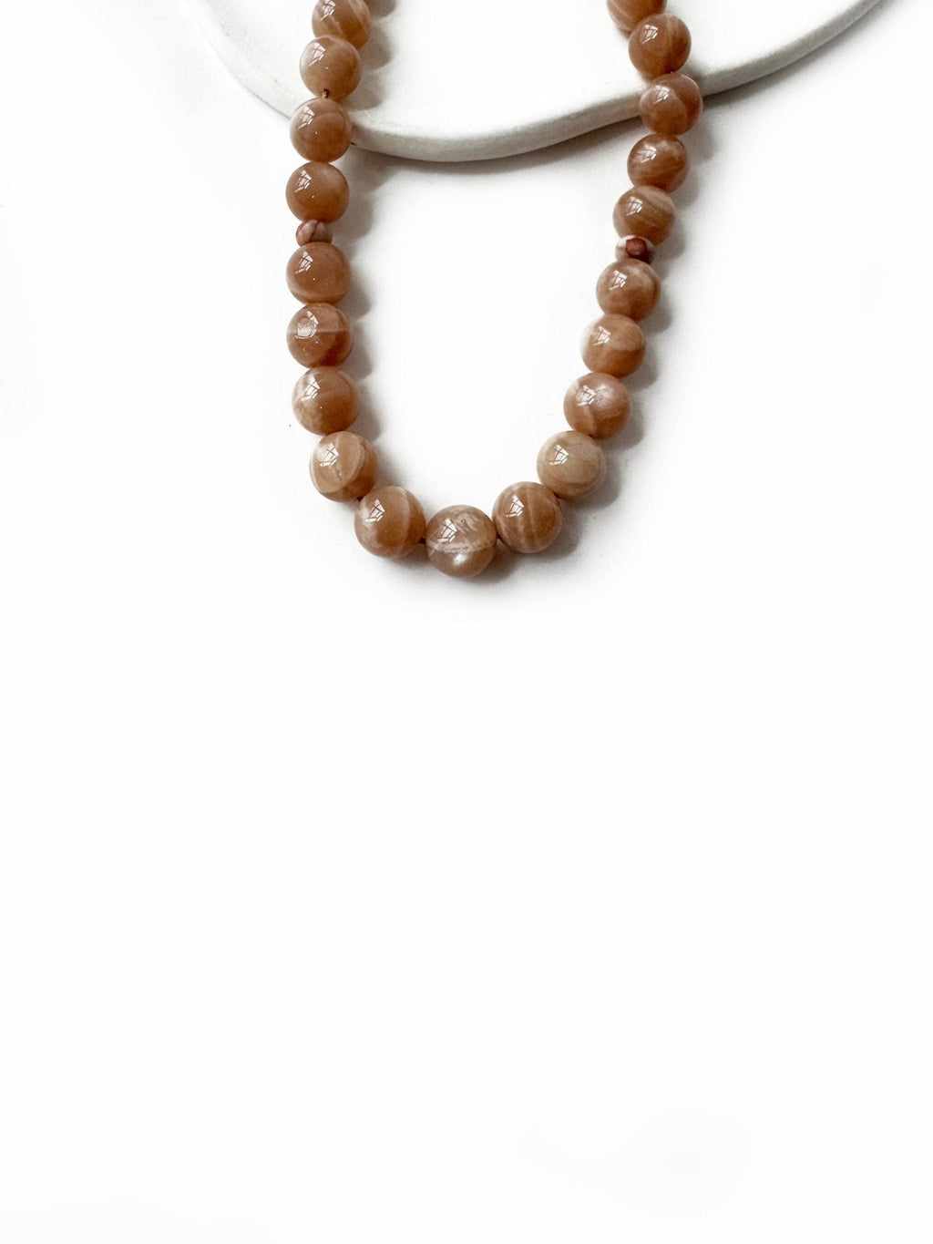 Golden-orange tones of sunstone tasbih beads symbolizing spiritual light
