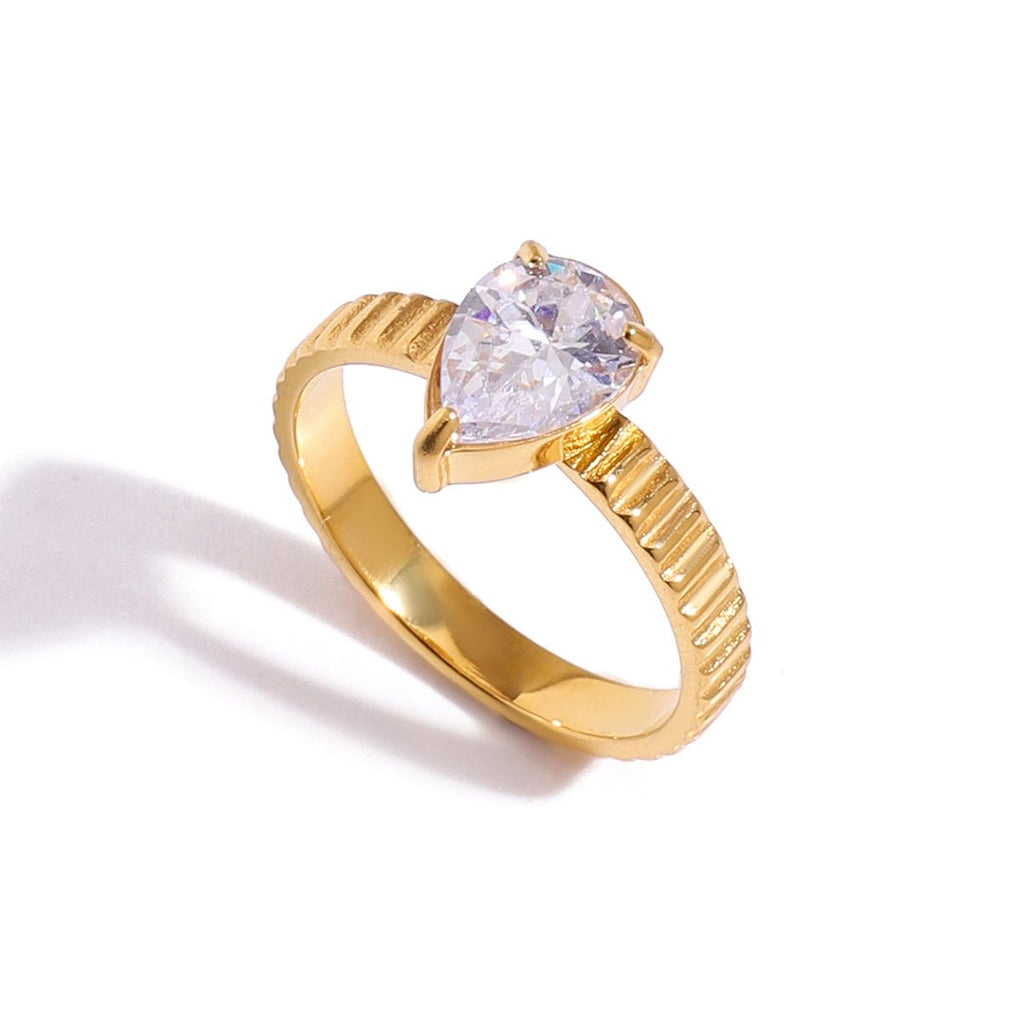 Gold ring with a large clear gemstone on a white background