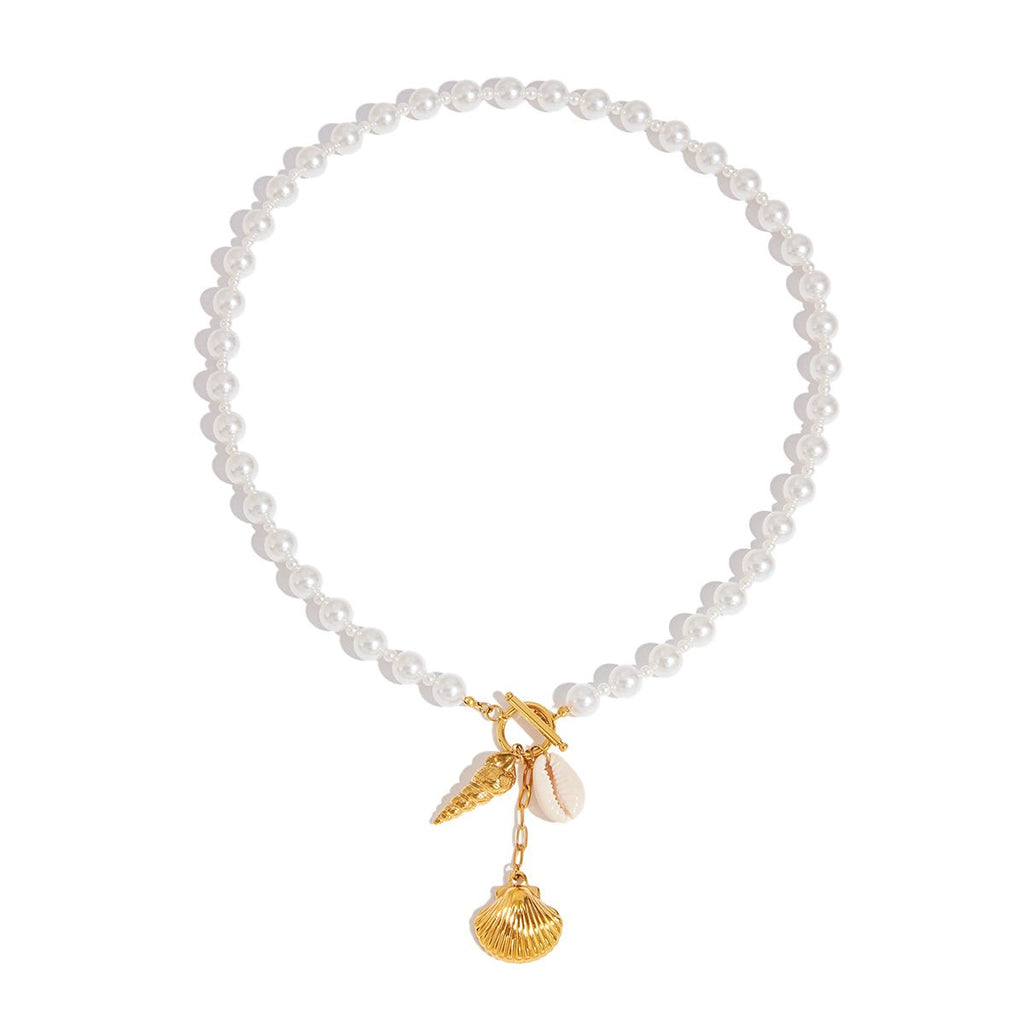 Pearl bracelet with gold charm featuring a leaf and shell on a white background