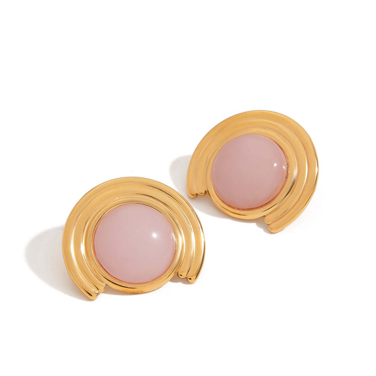 Pair of gold earrings with pink stones on a white background