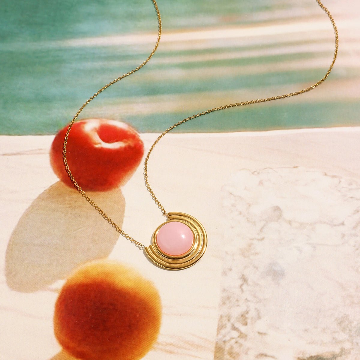 Necklace with a pink pendant on a beach setting Pink opal pendant necklace in gold-filled setting

