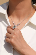 Platinum-plated ring with bold green center stone and crystal surround