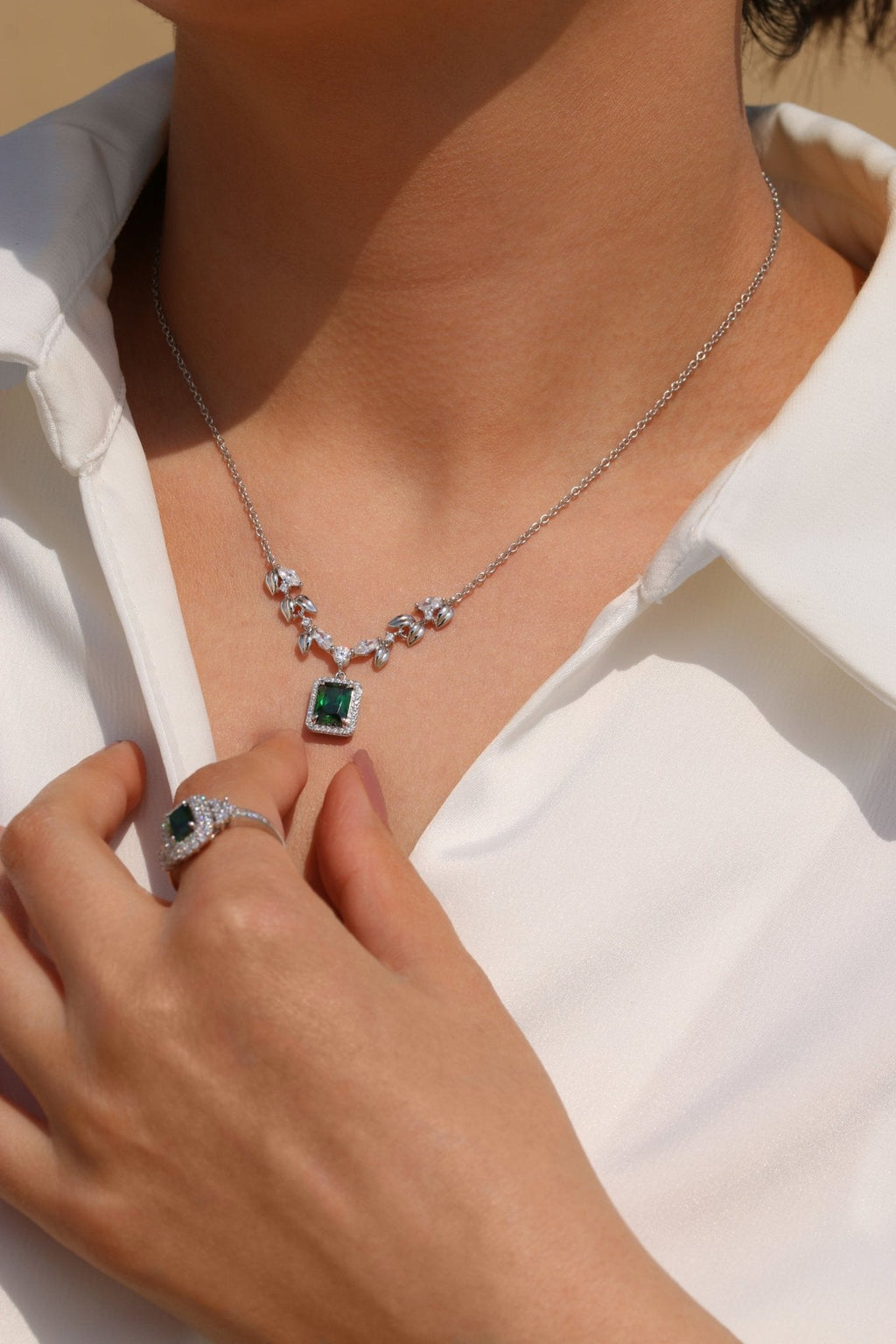 Green gemstone necklace with leaf-shaped zirconia details and platinum finish