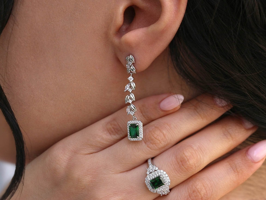 Close-up of green zirconia drop earrings in silver setting