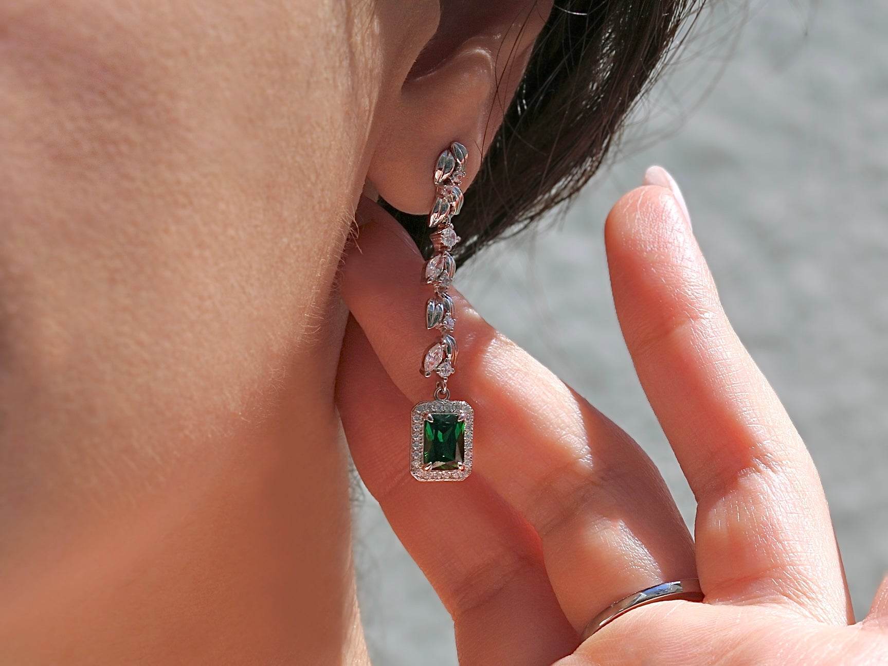 Luxury green gemstone earrings with platinum finish and crystal halo