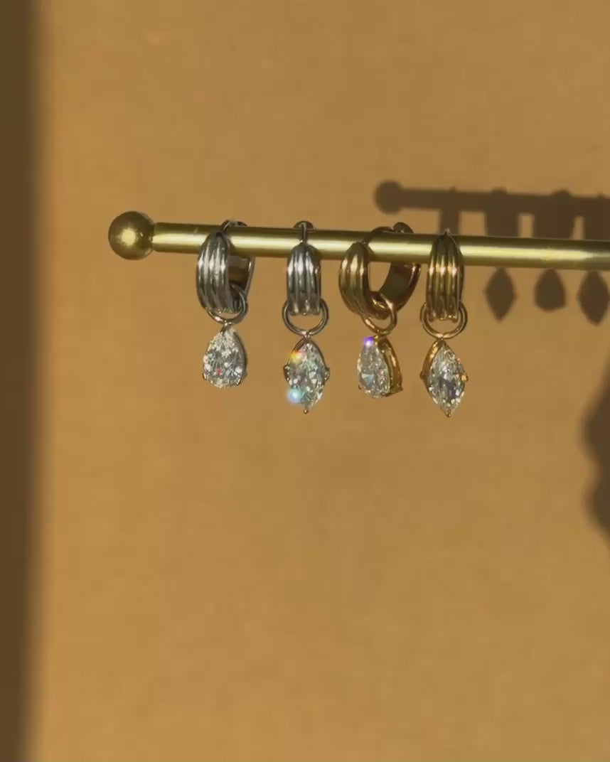  Close-up of elegant drop earrings catching the light, showcasing the brilliant shine and sparkle of the embedded gemstones.