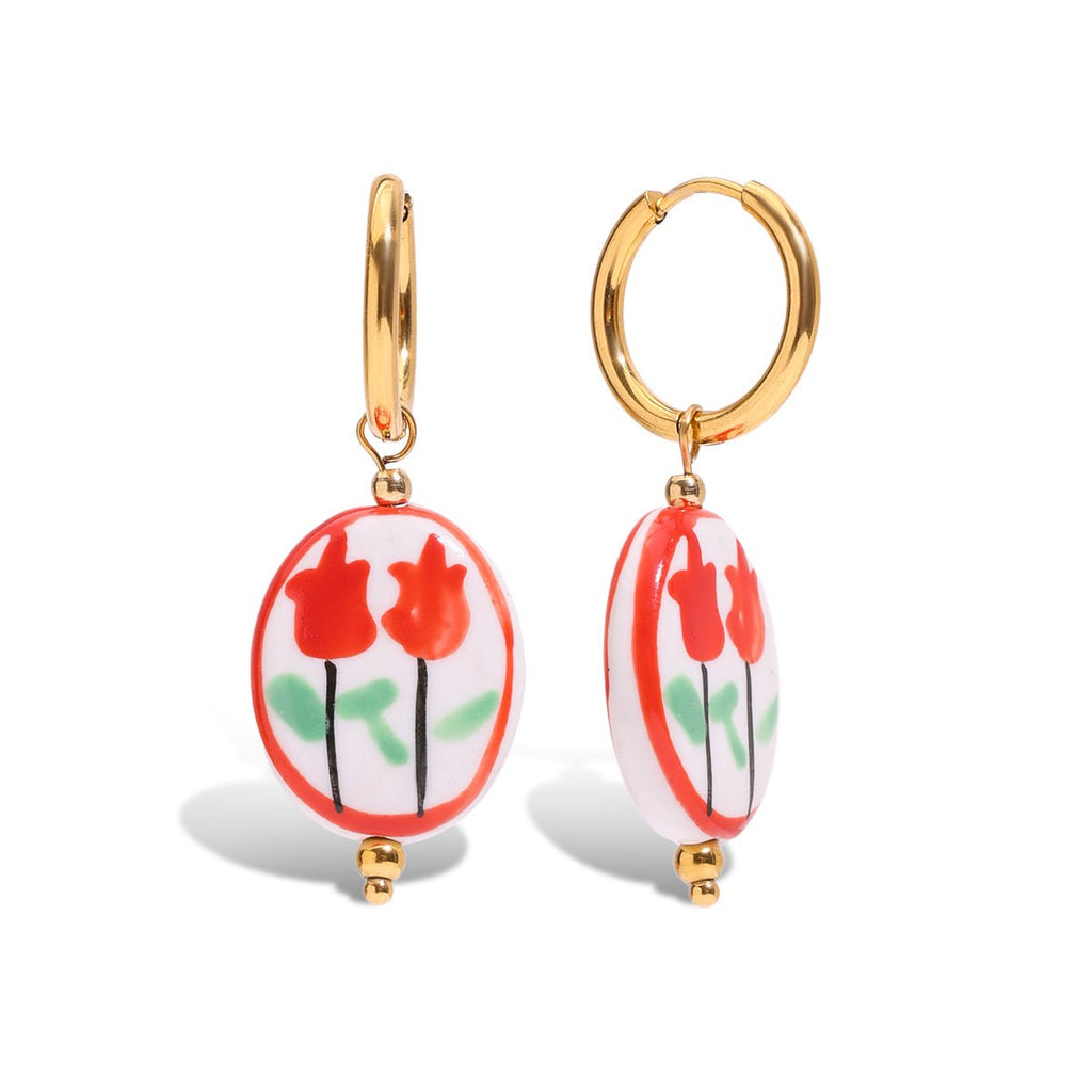 Gold hoop earrings with red floral designs on a white background