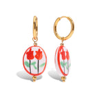 Gold hoop earrings with red floral designs on a white background