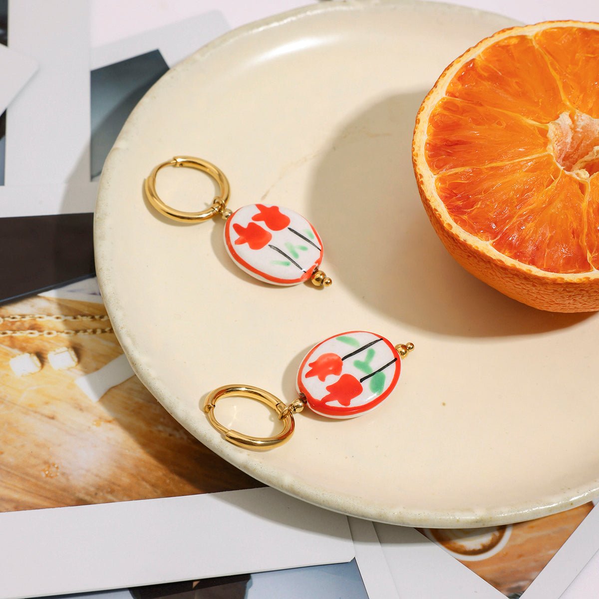 Two keychains with floral designs on a plate with an orange