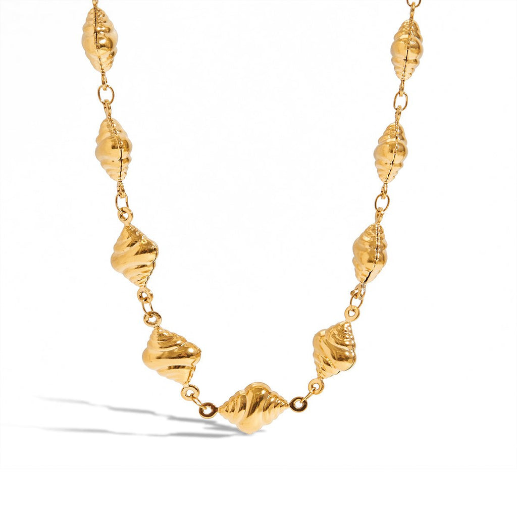 Gold necklace with shell-like beads on a white background