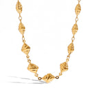 Gold necklace with shell-like beads on a white background