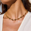 Gold necklace on a person wearing a white top