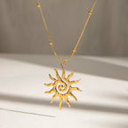 Gold sun-shaped pendant necklace on a neutral background