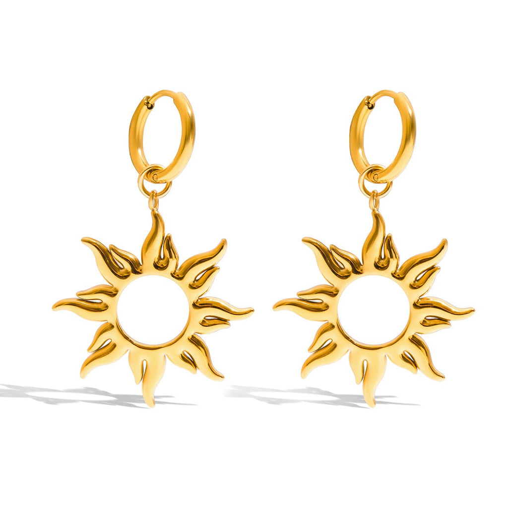 Gold sun-shaped earrings on a white background