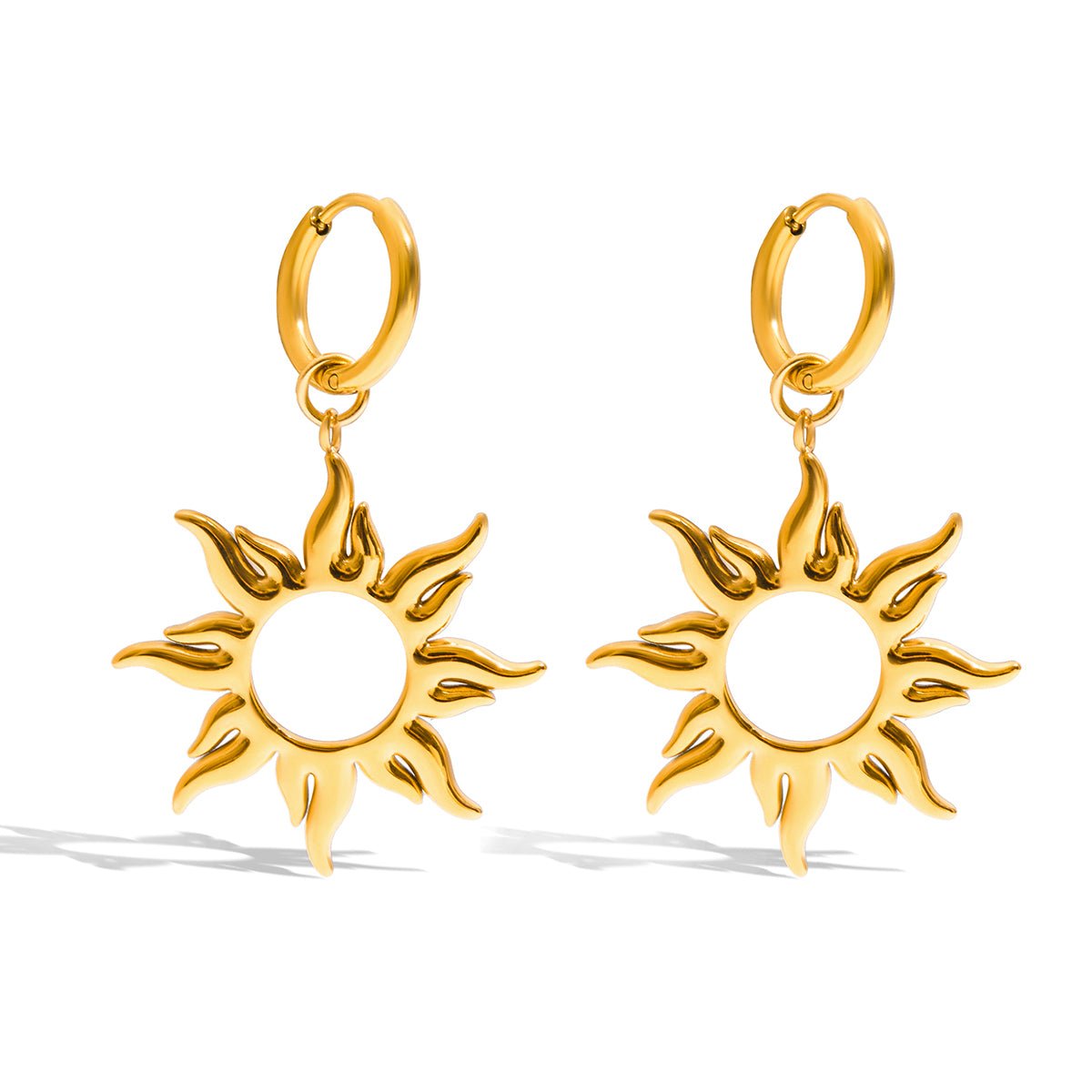 Gold sun-shaped earrings on a white background