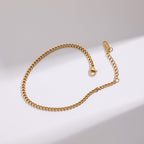 Gold chain bracelet on a light gray background