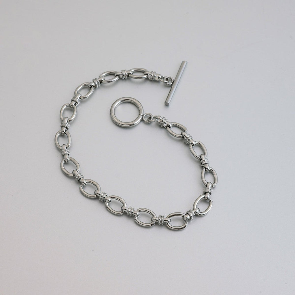 Silver chain bracelet on a light gray background