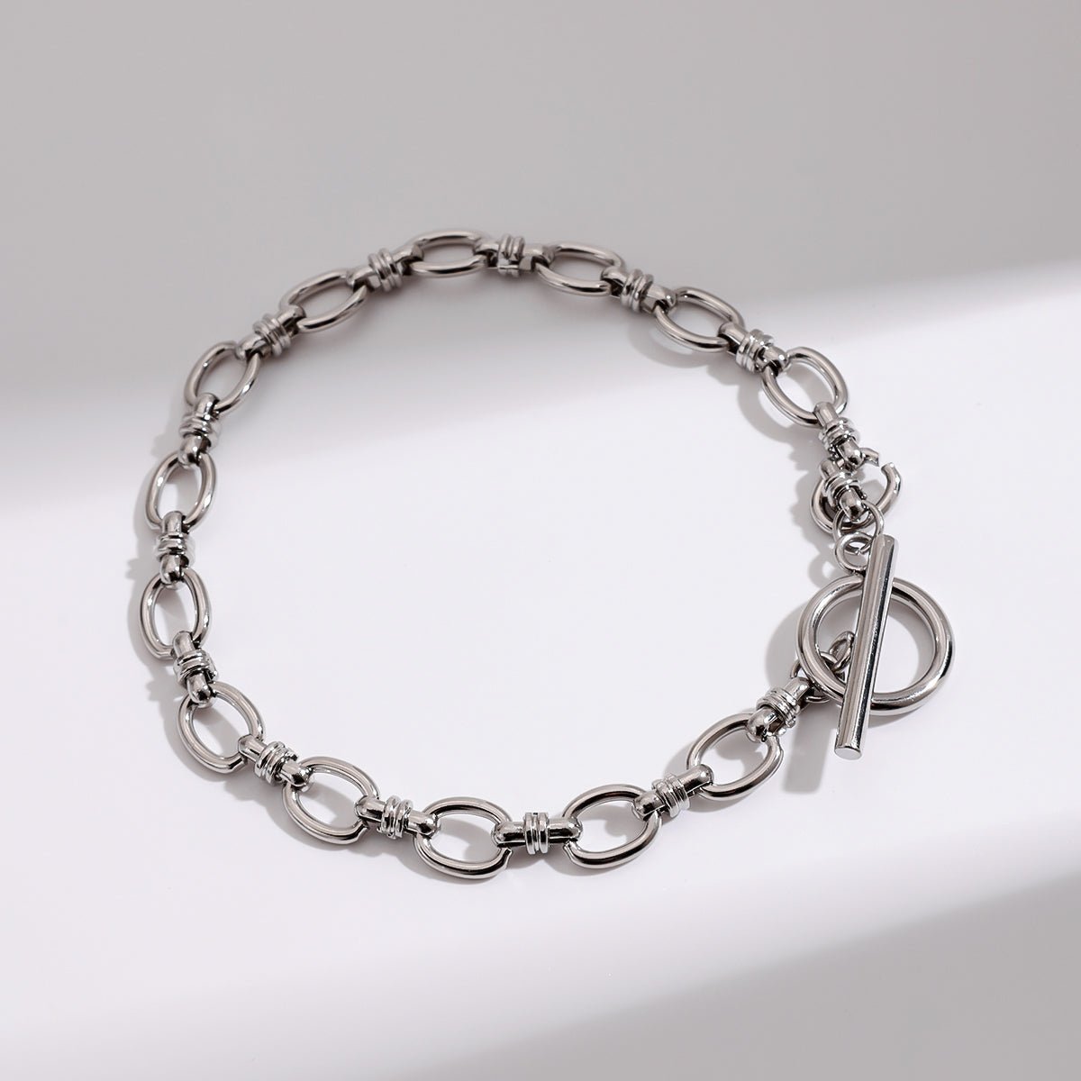 Silver chain bracelet on a light gray background
