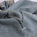 Silver chain necklace with a pendant on denim fabric